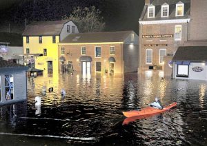 Associated Press Jim Davis kayaks through waters flooding Bowen’s Wharf in October 2012 after Superstorm Sandy in historic Newport, R.I