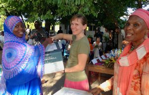 Elin hands a box to a Tanzanian Woman