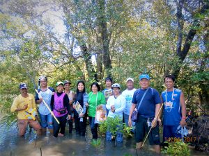 Group line-up photo of Filippinos standing in mangrove estuary